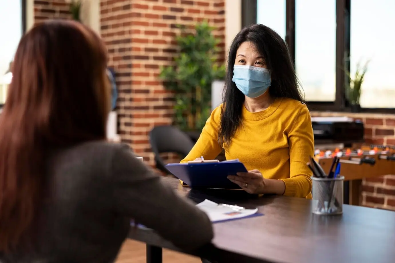 Eine Managerin hält im Büro ein Klemmbrett.