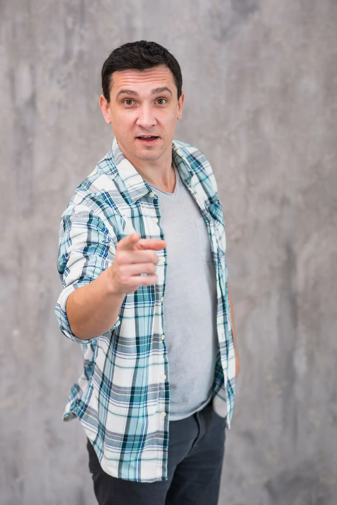 Junger, erstaunter Mann, der auf die Kamera zeigt.